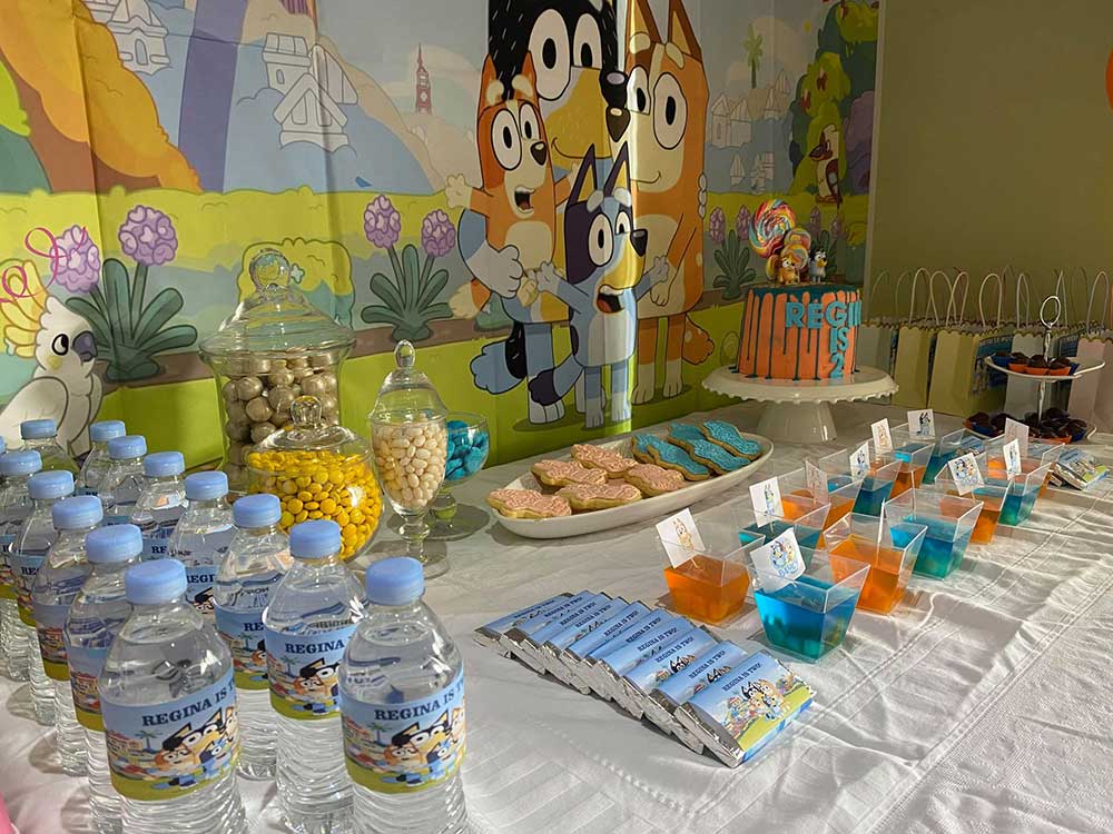 Bluey party table set up with water bottles. jelly, and Bluey chocolates