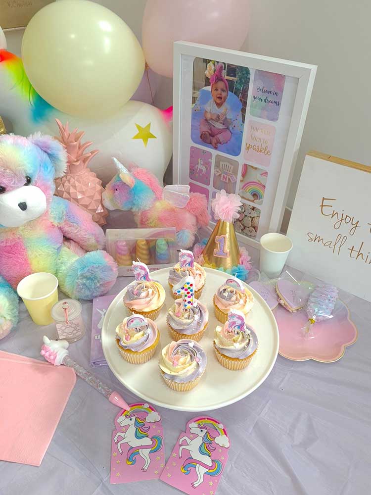 Unicorn party theme cupcakes on a table