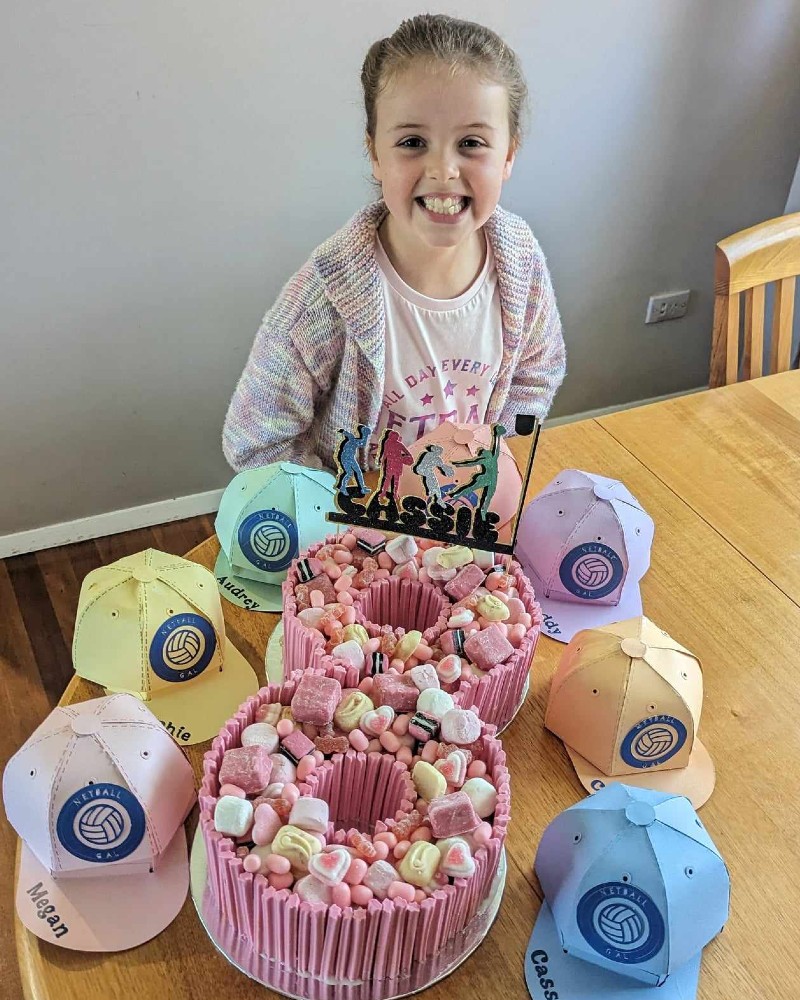 Netball party birthday celebrant with her party favours and cake