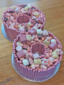 Number eight birthday cake filled with pink lollies.
